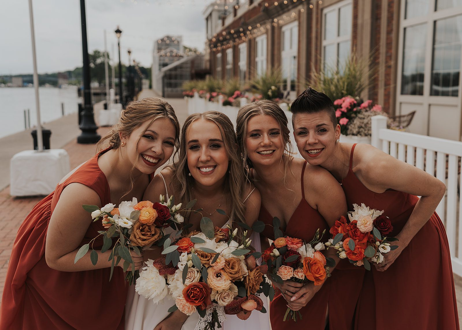 bride with her bridal party smiling at the camera