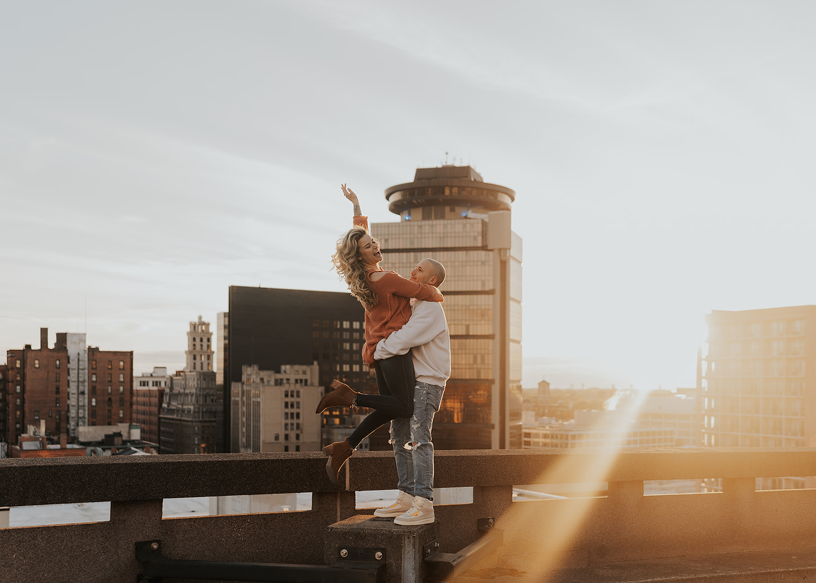 Fun couples photo on top of a parking garage in rochester ny for their engagement session