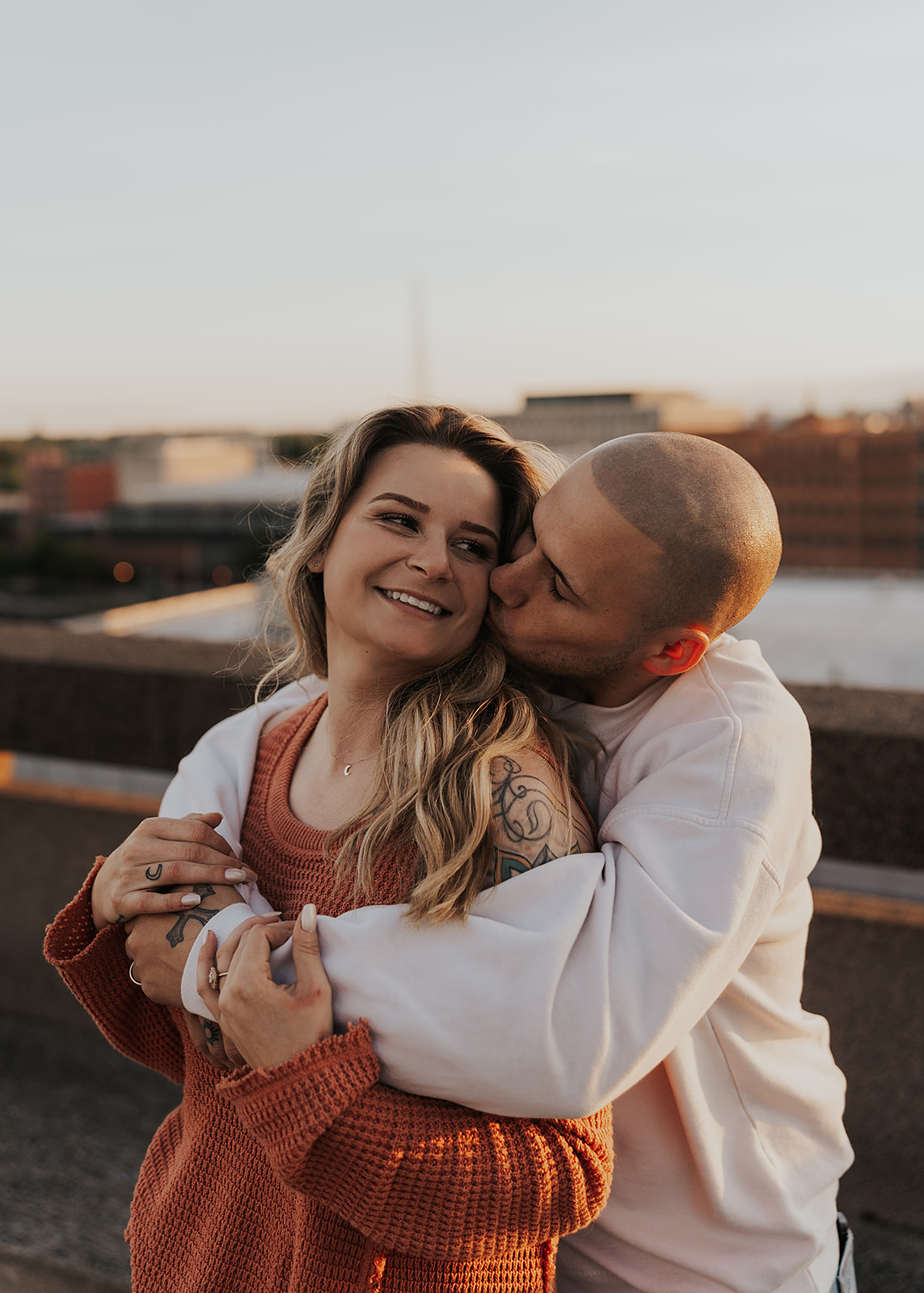 girl smiling while finace kisses her cheek during their engagement session