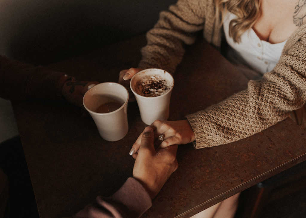 couple holding hands at coffee shop