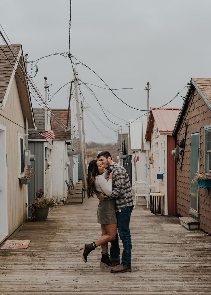 engaged couple embracing on a pier in Rochester NY during their engagement photoshoot