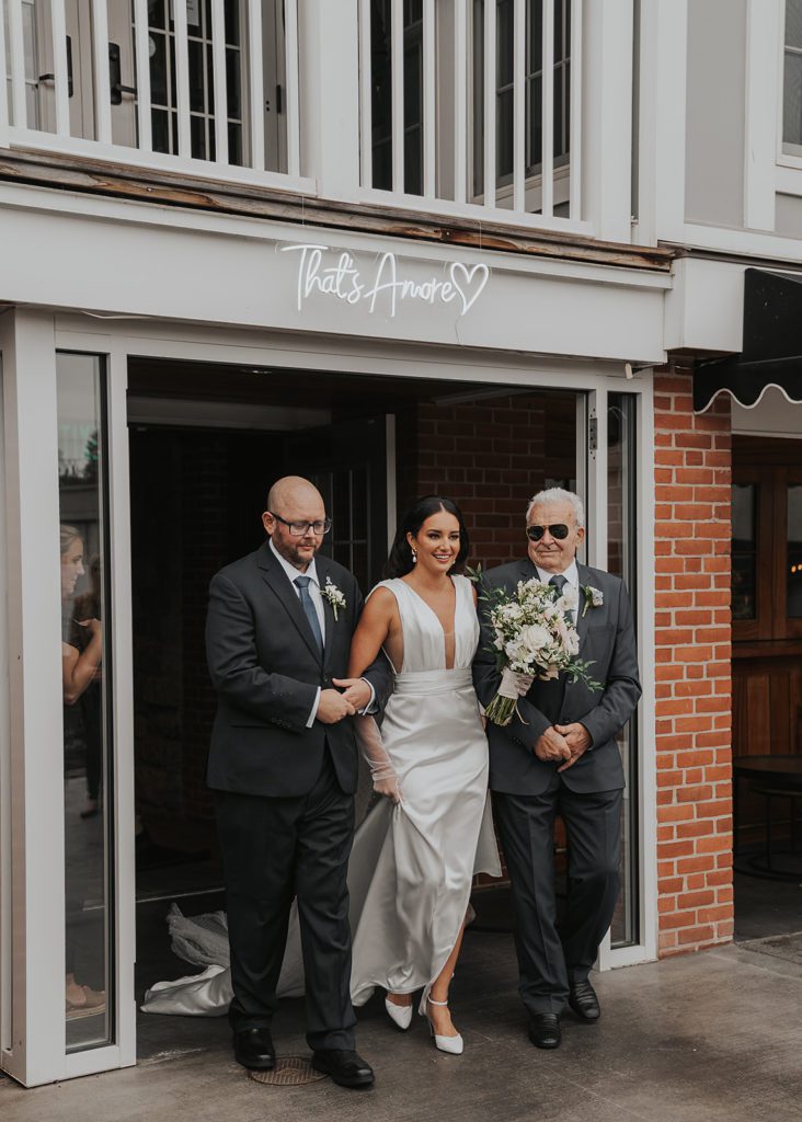 bride walking down the aisle with her dad at farmers creekside tavern in rochester ny
