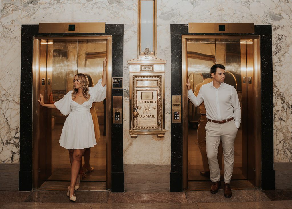 engaged couples standing the elevators at the hermitage hotel in tennessee for their destination engagement photoshoot
