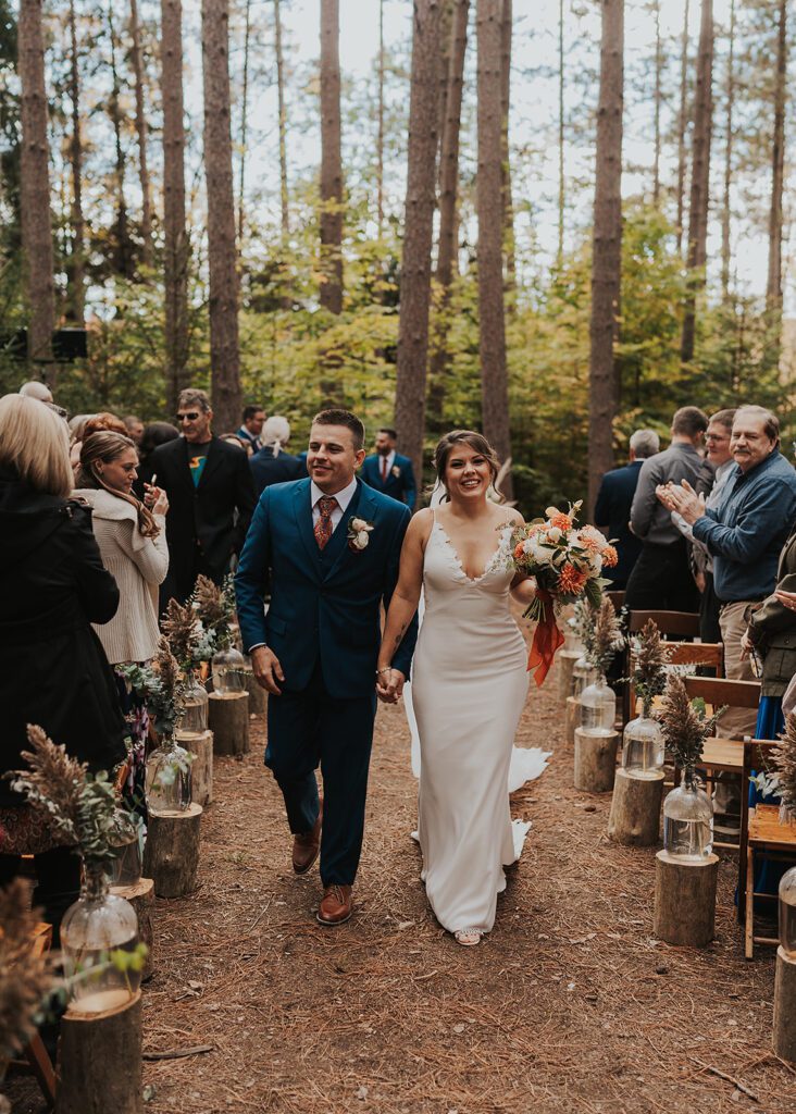 Bride and Groom walking down the aisle of their forest wedding at cummings nature center a rochester ny wedding venue