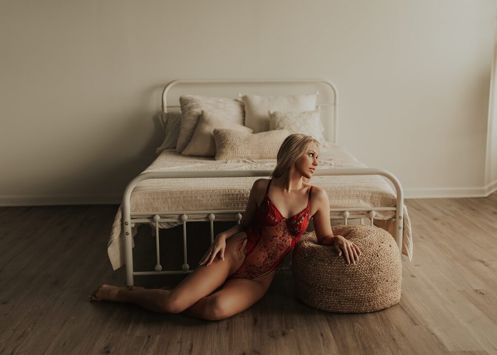 women wearing red lingerie laying on the floor during her boudoir photoshoot at gallery 48 photography studio