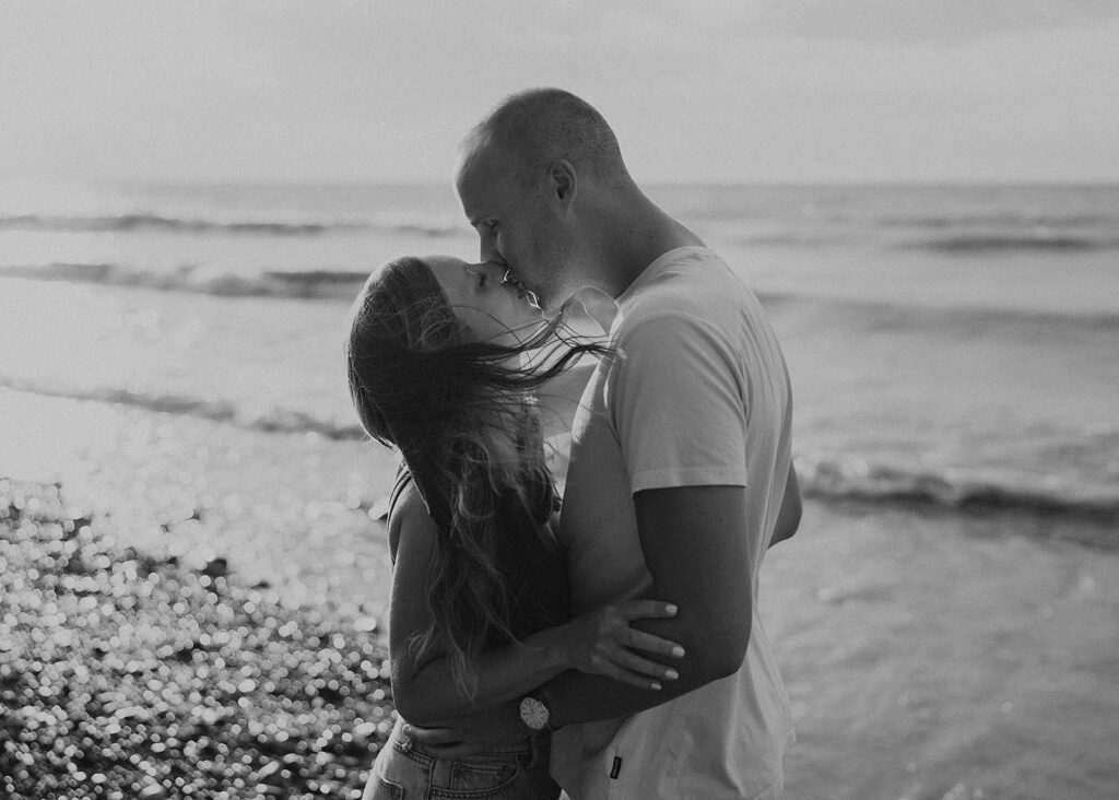 engaged couple kissing on the beach during their beach engagement photoshoot