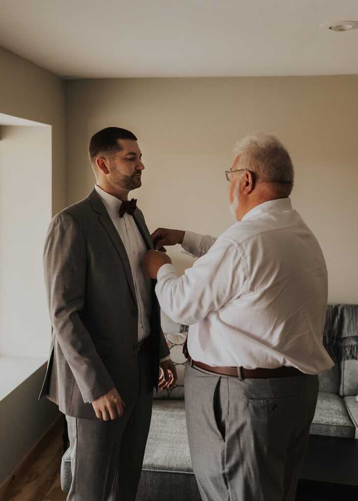 grooms father adjusting his suit