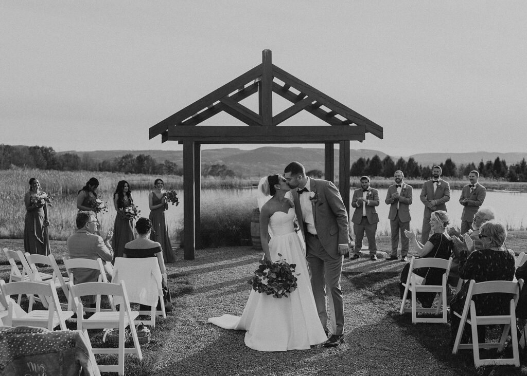 black and white image of bride and groom walking down the aisle after their ceremony at wrens roost in rochester ny