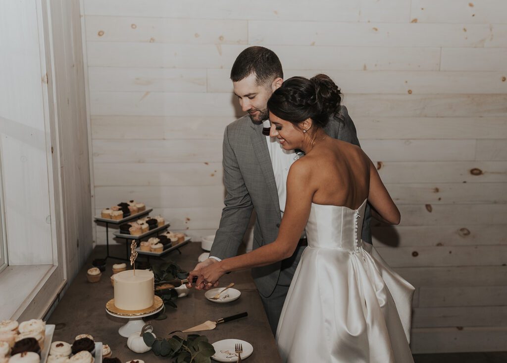 bride and groom cutting their wedding cake after their wedding ceremony at wrens roost wedding venue in rochester ny
