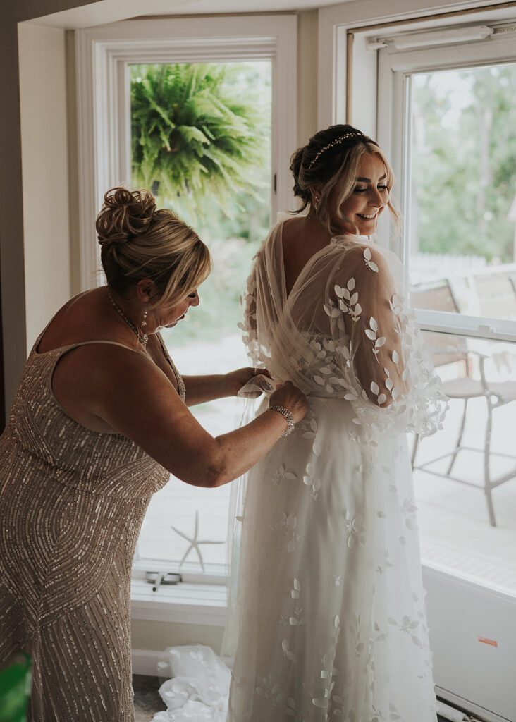 mom zipping up brides dress as she gets ready for her wedding in jamaica