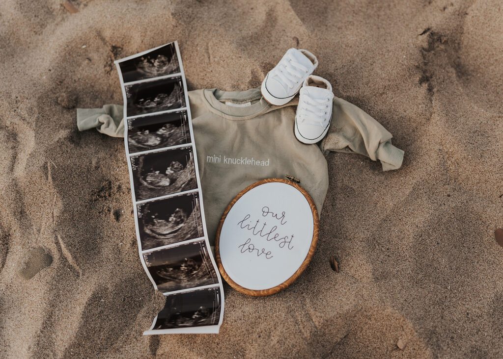flatlay of baby announcement on the beach